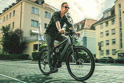 Si vede un uomo su una bicicletta Winora che attraversa il centro città.