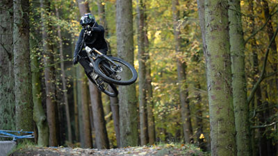 Ciclista con casco integrale salta in aria con una mountain bike Cube Stereo ONE77 Fully.