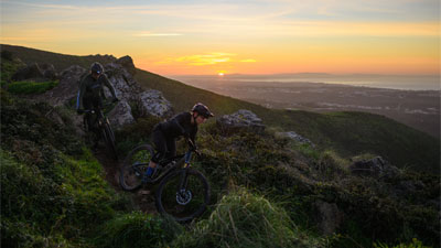Due ciclisti scendono da una montagna, ciascuno su una mountain bike Cube Stereo Fully.