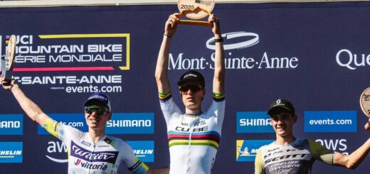 Finn Treudler festeggia alla finale di stagione del Cube Factory Racing 2025 a Mont-Sainte-Anne, tenendo il trofeo tra le mani, affiancato dai ciclisti arrivati al secondo e al terzo posto sul podio.