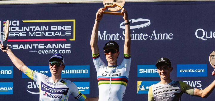 Finn Treudler festeggia alla finale di stagione del Cube Factory Racing 2025 a Mont-Sainte-Anne, tenendo il trofeo tra le mani, affiancato dai ciclisti arrivati al secondo e al terzo posto sul podio.