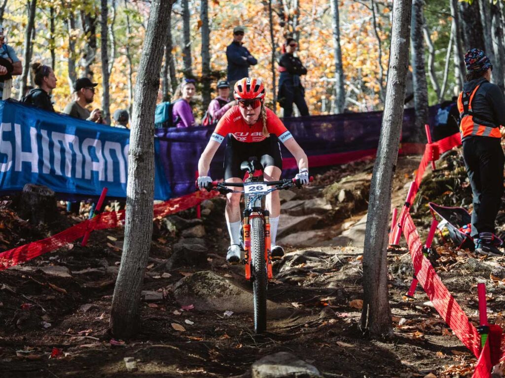 Kira Böhm percorre con la massima concentrazione il tratto boschivo tecnico durante la finale di stagione del Cube Factory Racing 2025 a Mont-Sainte-Anne sulla sua mountain bike Cube. Kira Böhm percorre con la massima concentrazione il tratto boschivo tecnico durante la finale di stagione del Cube Factory Racing 2025 a Mont-Sainte-Anne sulla sua mountain bike Cube.